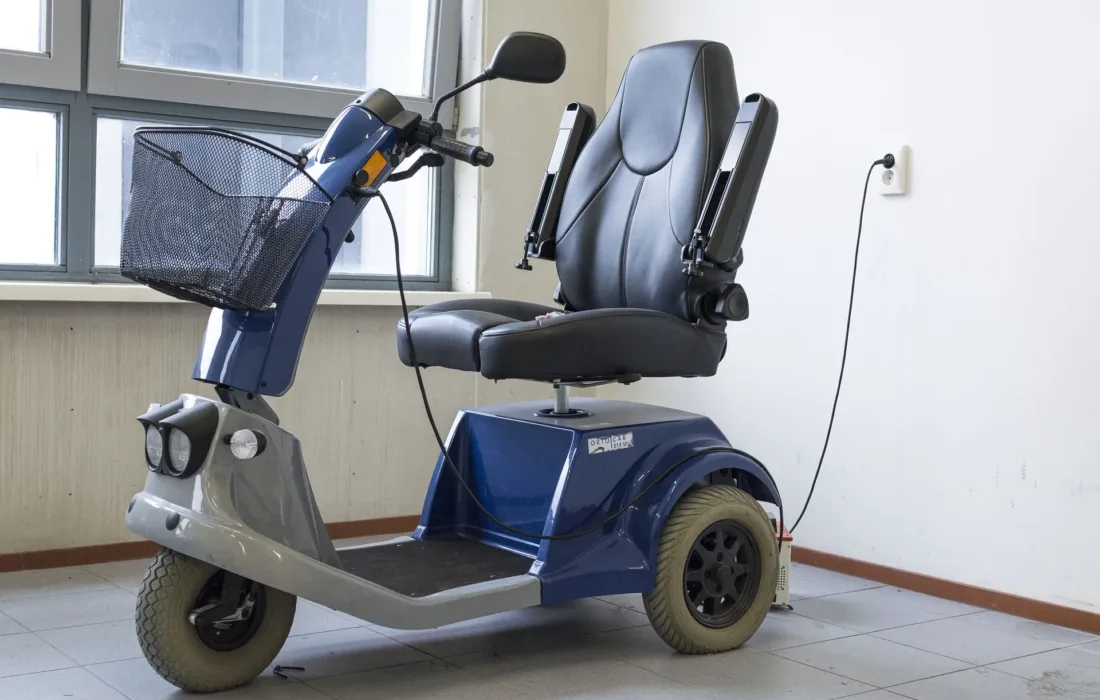 Blue Scooter charging against a wall