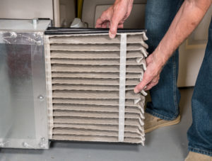 A man changes an HVAC filter.