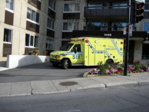 An ambulance sitting in the parking bay of an apartment building