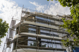 A building under construction covered in scaffolding.