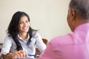 A woman talking to a man from across a desk