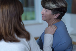 A woman with her hand on another woman's shoulder