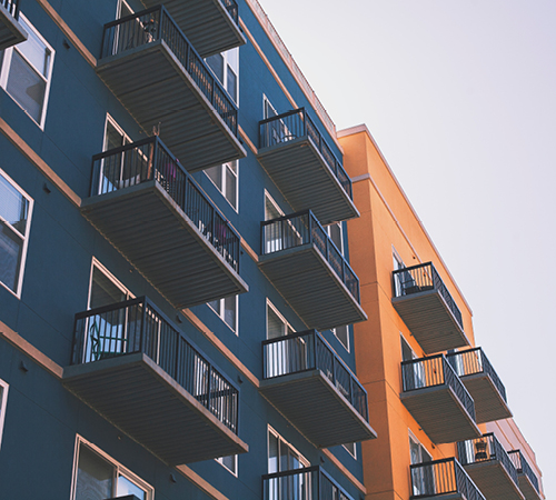 Exterior of two rental apartment buildings set against the sky