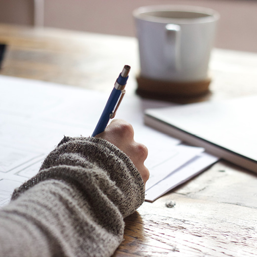 Close up of a woman's hand writing with a pen