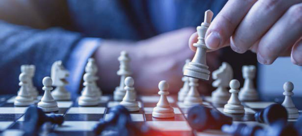A hand hovers over a chessboard