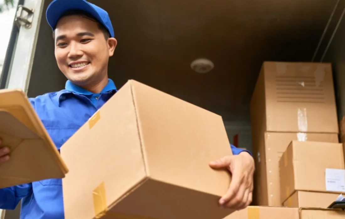 Delivery man holding a box and clipboard