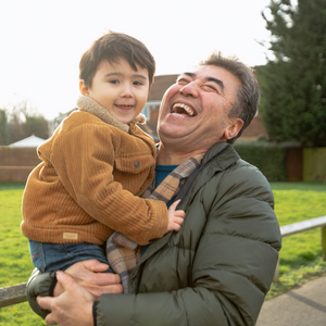 Man laughing and holding a young child