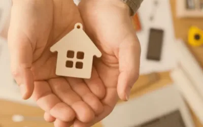 Woman's hands holding a wooden house