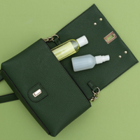 Green purse with hand sanitizer sticking out of it