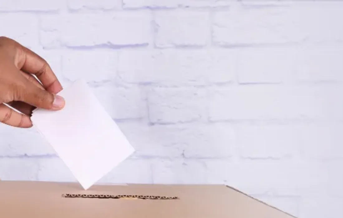 Hand placing ballot in ballot box