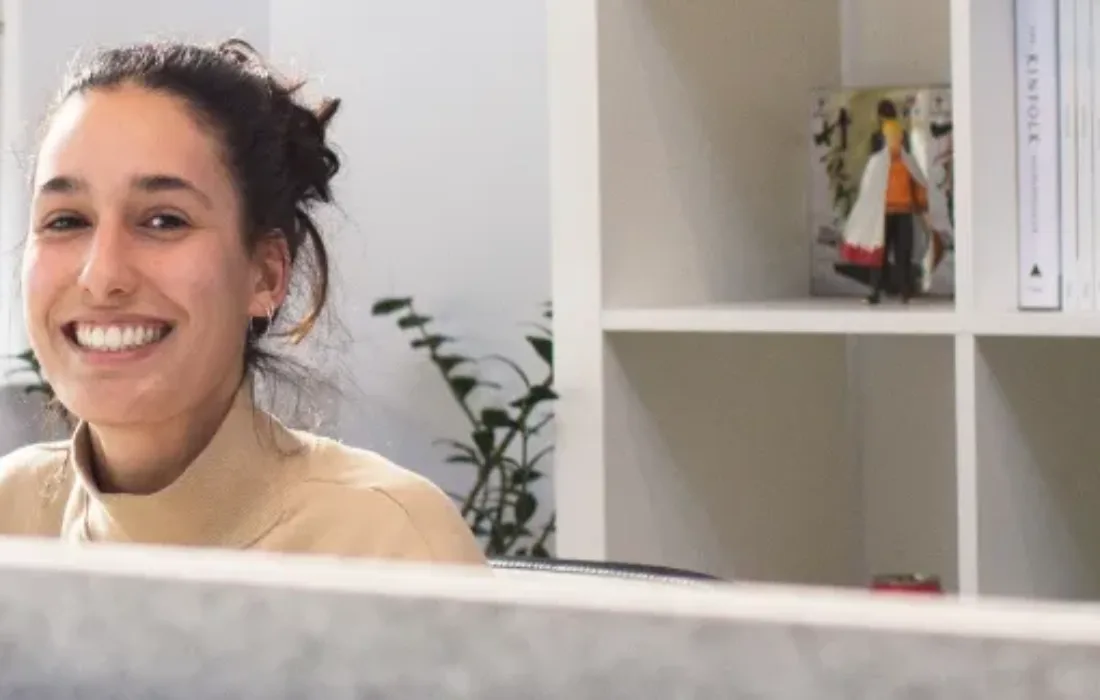 Woman sitting at a work desk, smiling