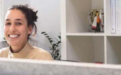 Woman sitting at a work desk, smiling