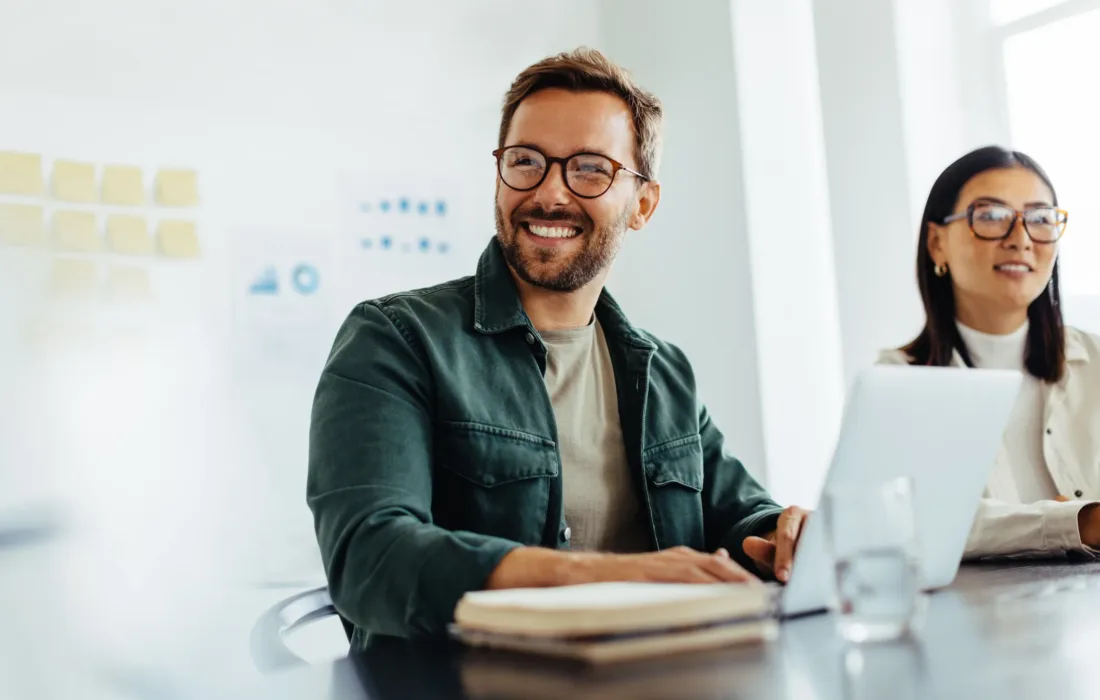 Happy person listening to a discussion. Business professional sitting in a meeting with his colleagues.