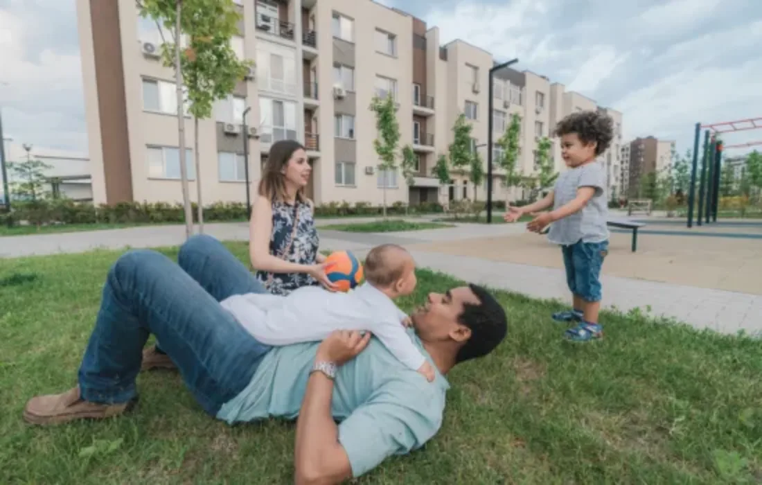 Family playing outside of a community housing building