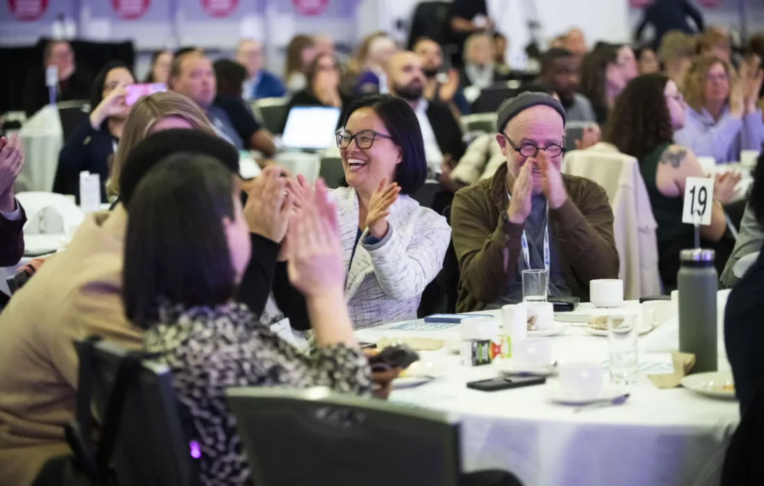 People clapping sitting in the main ballroom