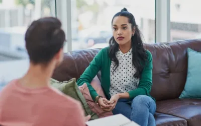 Two people sitting on a couch while having a conversation